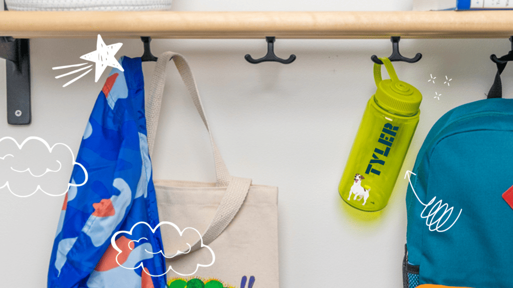 Customized Nalgene water bottle with the name "Tyler" and dog sticker handing from classroom coat hook.